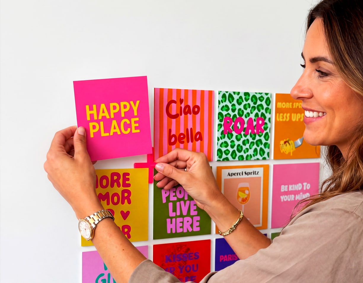 A woman adding a Happy shape to her wall next to other Happy shapes.